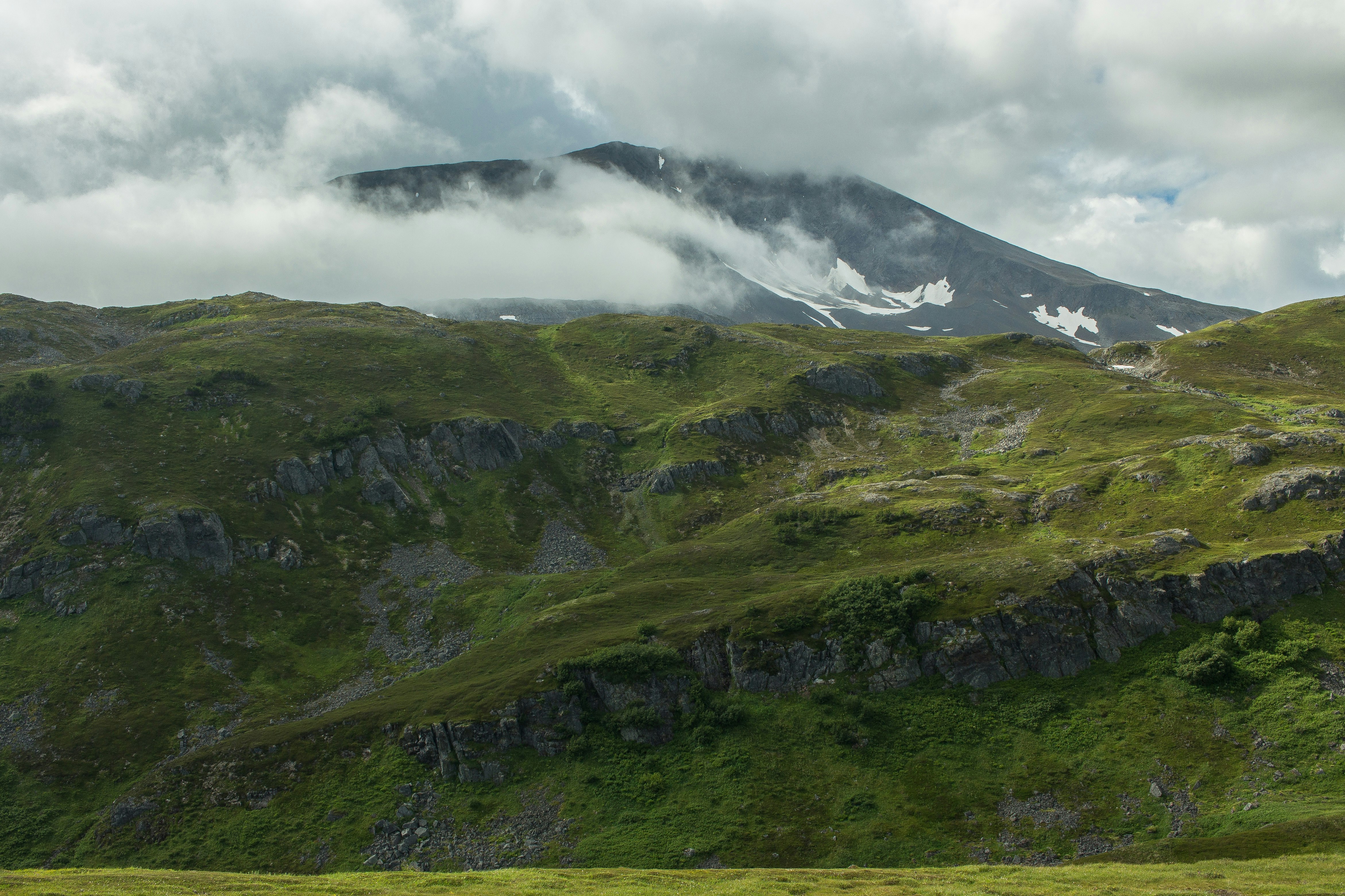 green mountain under cloudy sky during daytime